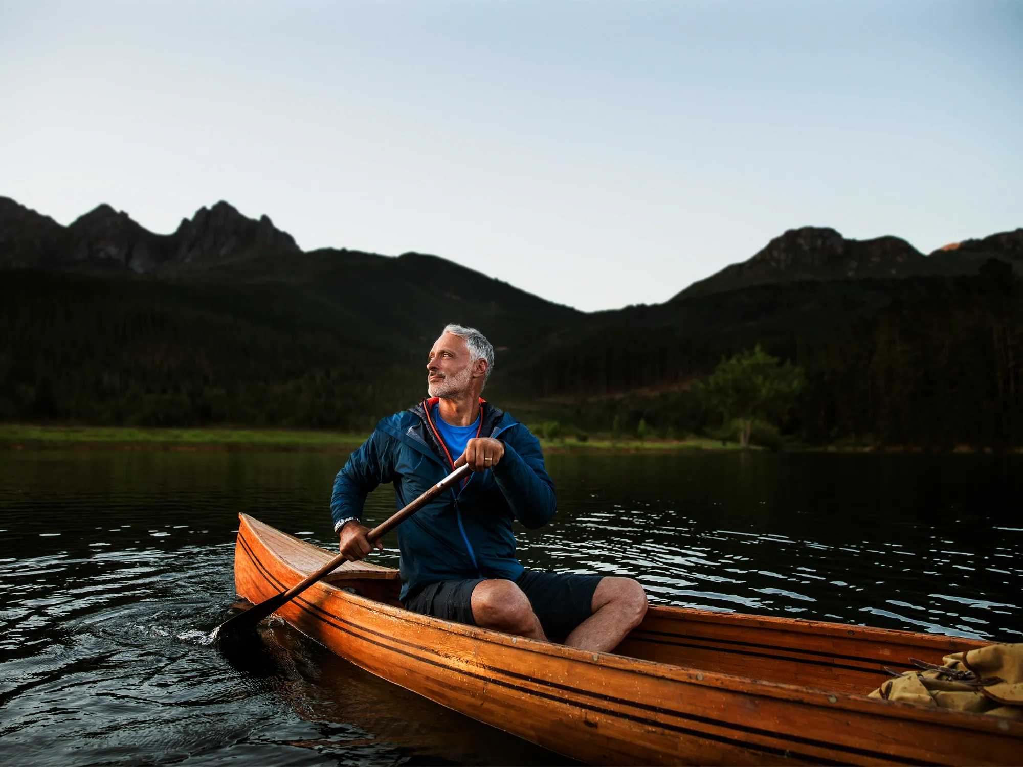 Man canoeing in a river using hearing aids